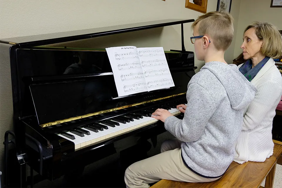 Kasia teaching student to play piano