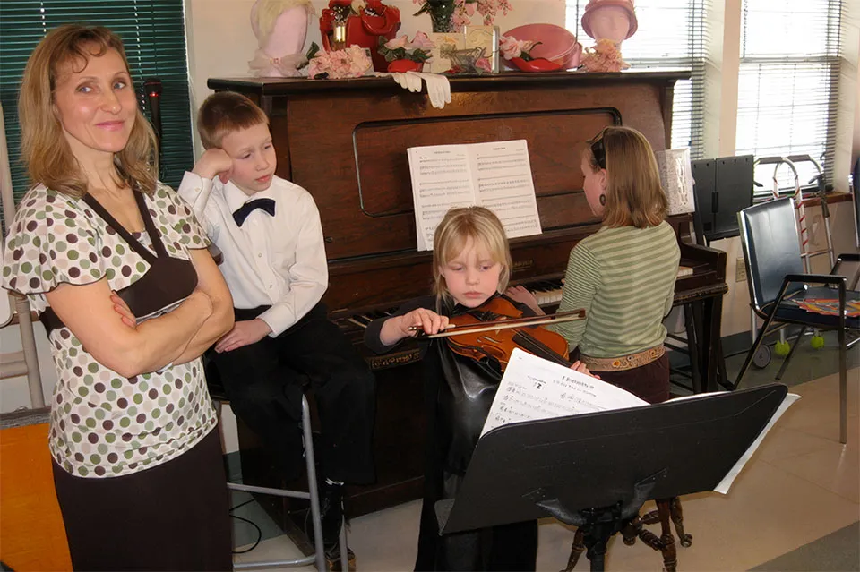 Kasia with family and students performing with violin and piano