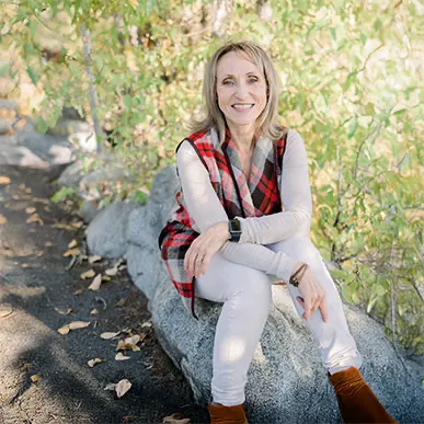 Kasia sitting on a rock in the forest